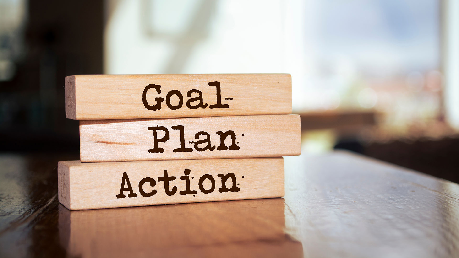 Blocks stacked on top of each other that reads Goal, Plan, Action.