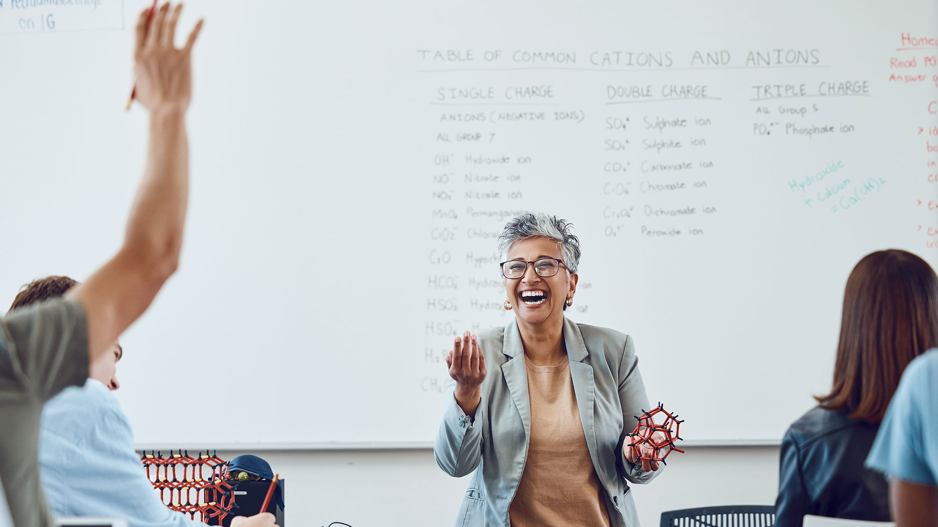 Teacher laughing in front of classroom.